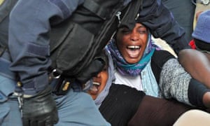 Italian police use force to remove people, mostly from Sudan and Eritrea, who have been camped out for days near the border crossing with France.