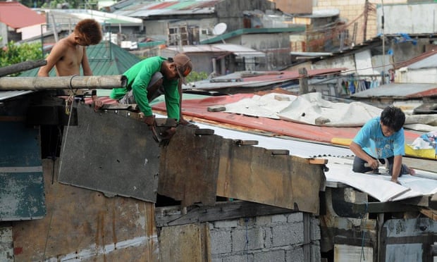 Residents along Manila Bay repair their roofs as they wait for typhoon Noul to arrive on Sunday.