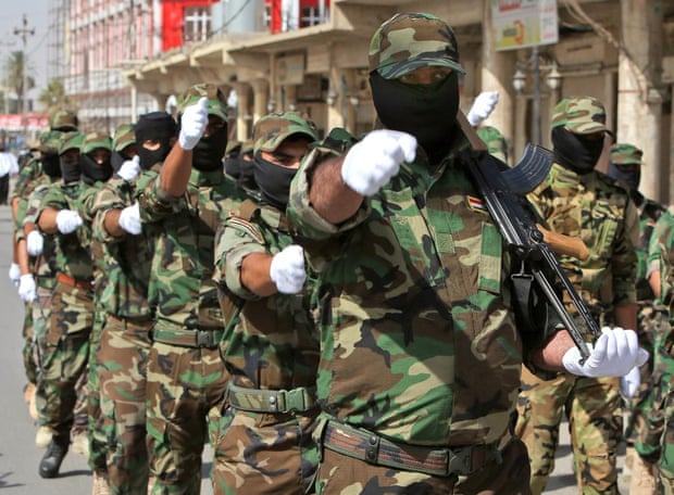 Shia militiamen parade in northern Iraq last June.