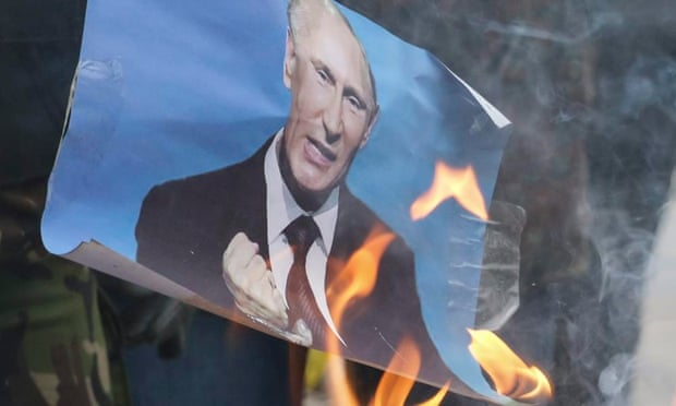 Protesters burn a portrait of Vladimir Putin at a memorial march for Boris Nemtsov, in Mariupol, Ukraine.