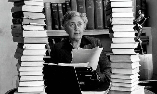 Agatha Christie sitting at her desk with books piled high. Poison was a favourite weapon in her books.