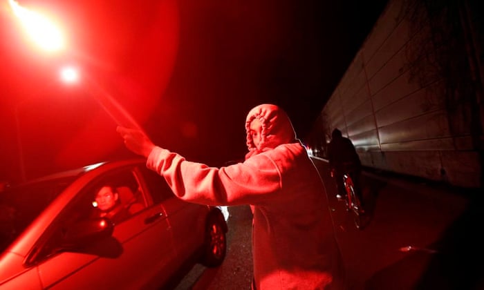 A protester holding a flare runs on Highway 580 in Oakland, California