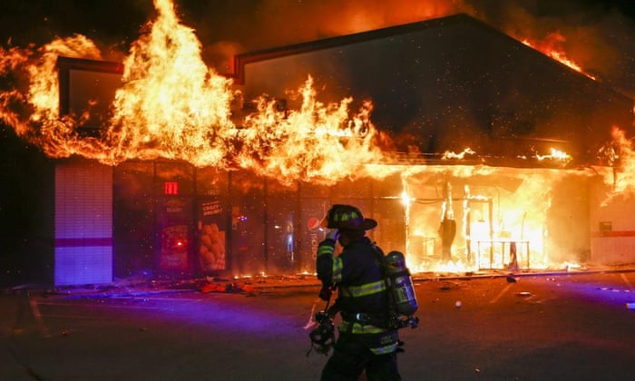 A firefighter arrives to inspect a pizza business set ablaze in Ferguson