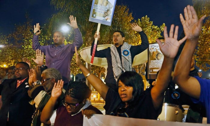 Activists hold their hand up as they protest at the Leimert Park area of Los Angeles, California