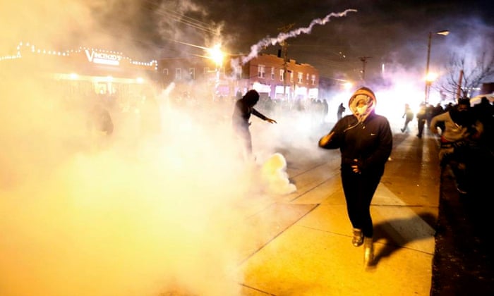 Protesters run from a cloud of tear gas in Ferguson