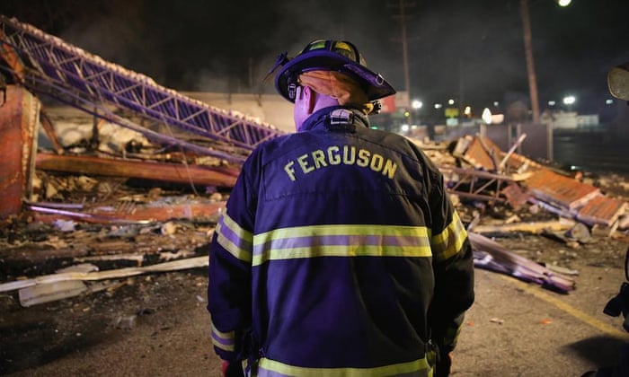 A Ferguson firefighter surveys rubble at a strip mall that was set on fire when rioting erupted following the grand jury announcement in the Michael Brown case