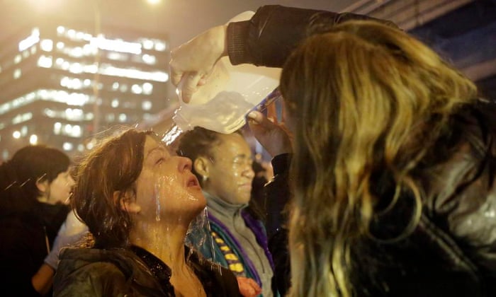 A woman gets water poured on her face after police pepper sprayed demonstrators attempting to stop traffic on Interstate 5 in Seattle, Washington