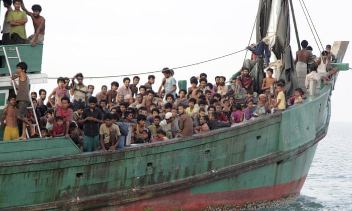 Migrants sit on a boat as they wait to be rescued by Acehnese fishermen on the sea off East Aceh, Indonesia.