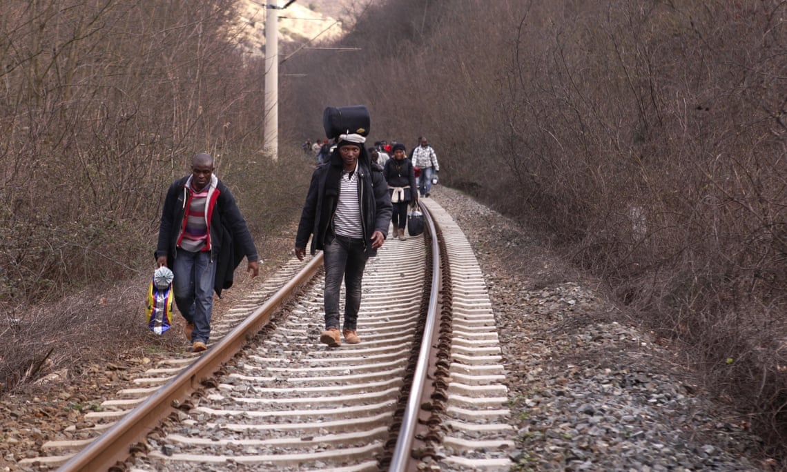 In this Saturday, Feb. 28, 2015 photo West African migrants walk on train tracks on their way towards the border with Macedonia near the town of Evzonoi, Greece.  The tide of hopeful migrants pours through the vulnerable 'back-door' countries in the hope of entering the 28-nation European Union, and although most people don't make it, the human tide continues to grow, according to Frontex, the EU agency that helps governments police the bloc s leaky frontiers.