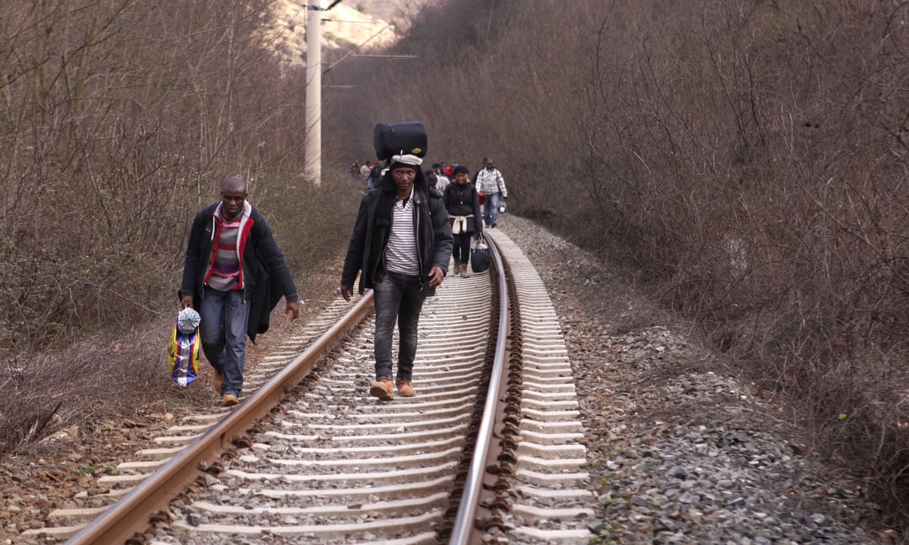 In this Saturday, Feb. 28, 2015 photo West African migrants walk on train tracks on their way towards the border with Macedonia near the town of Evzonoi, Greece.  The tide of hopeful migrants pours through the vulnerable 'back-door' countries in the hope of entering the 28-nation European Union, and although most people don't make it, the human tide continues to grow, according to Frontex, the EU agency that helps governments police the bloc s leaky frontiers.