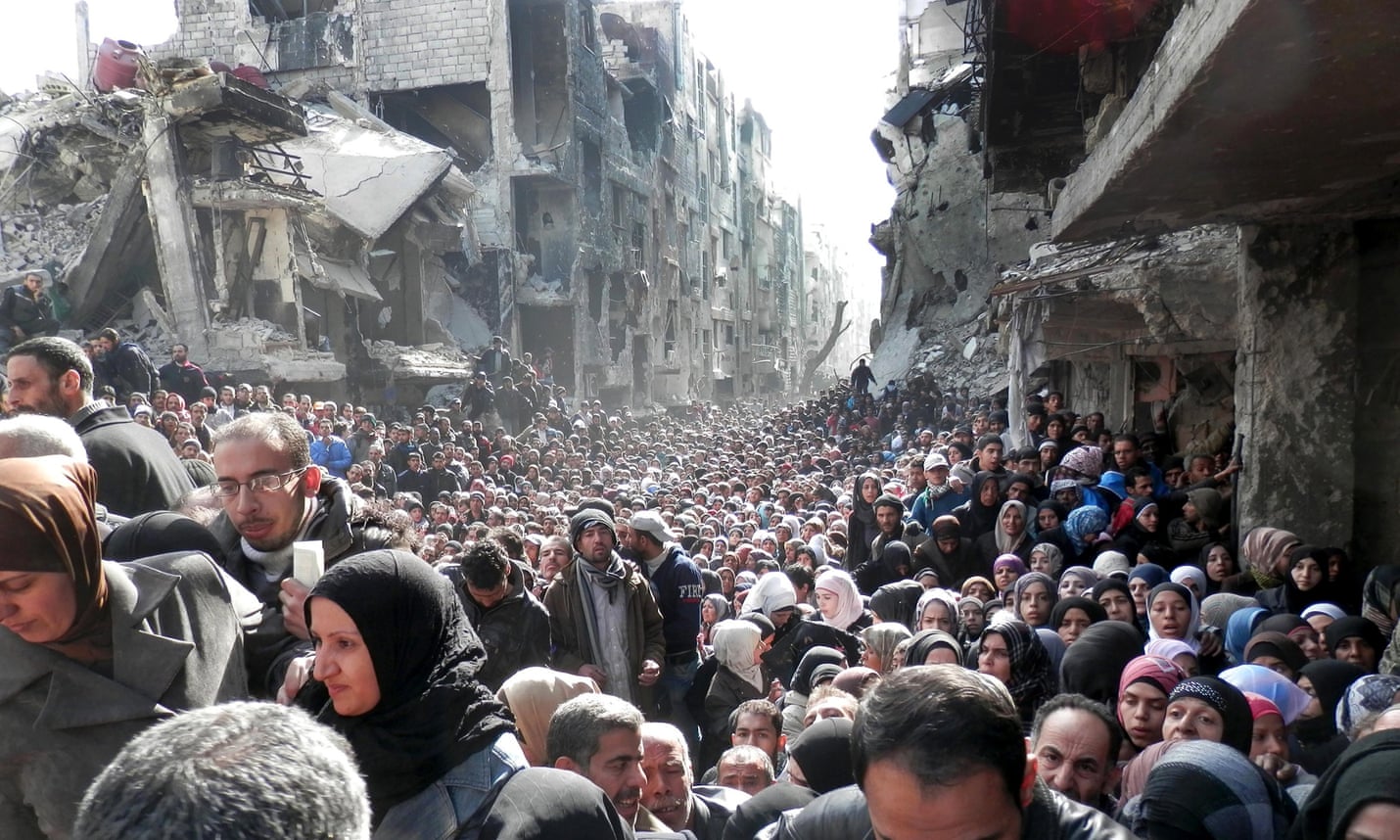 Palestinian refugees in Yarmouk, Damascus, queueing for food.