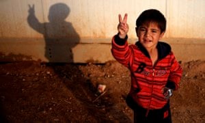 Syrian boy Rayyan Nasser makes a peace sign at Zaatari refugee camp in Mafraq, Jordan