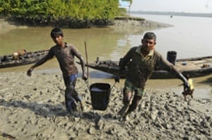 Villagers carrying oil removed from the river surface in Joymani village, Sundarbans, Bangladesh.