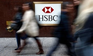 People walk past a branch of HSBC.