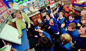 Pupils being taught maths by teacher in primary school classroom