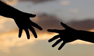 Two hands reach for each other against the sky