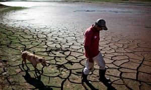A resident walks with a dog across the drying bottom of the Paraibuna dam in Redencao da Serra