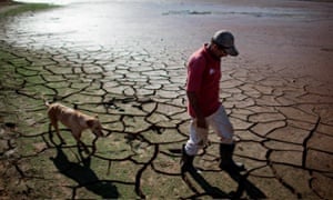 A resident walks his dog across the drying bottom of the Paraibuna dam, part of the Cantareira water system that provides greater Sao Paulo with most of its water.