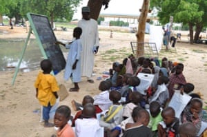 Children who fled their homes following an attacked by Islamist militants in Bama, take a lesson at a camp in Maiduguri, Nigeria