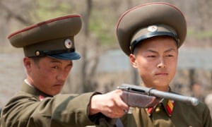 Two members of the Korean People's Army have a go on a firing range at a fair in Pyongyang, North Korea.