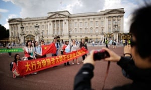 Model Chinese tourists outside Buckingham Palace.