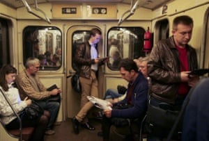 People using their tablets on a Moscow metro train.