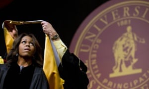 Michelle Obama is presented with a robe and honorary degree at the Tuskegee University's spring commencement.