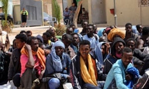 Migrants from sub-Saharan Africa sit at a centre for illegal migrants in the Libyan city of Misrata, as they wait to be transported to a different detention centre.