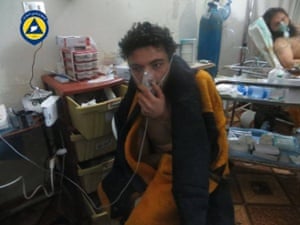 A victim of a chlorine attack holds an oxygen mask to his face at Sarmin hospital in a photograph taken by a Syrian civil defence group