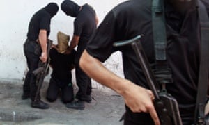 Hamas militants grab a Palestinian suspected of collaborating with Israel before being executed in Gaza City in August 2014.  