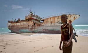 A Somali pirate in front of a hijacked fishing boat in 2012.