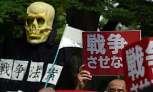Protesters hold banners as they attend a rally against the proposed defence changes in Tokyo.