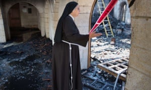 A nun inspects damage at the Church of the Multiplication at Tabgha.