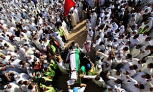 Mourners carry the body of one of the vi