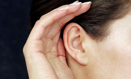 Woman cupping hand to her ear