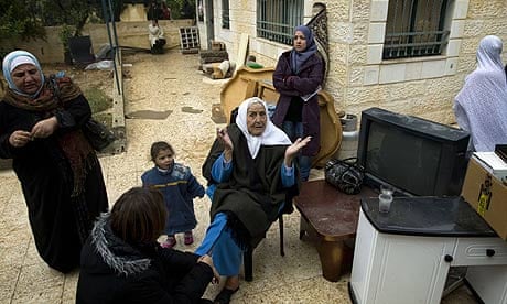 A Palestinian woman gestures as she sits in front of the disputed house in east Jerusalem