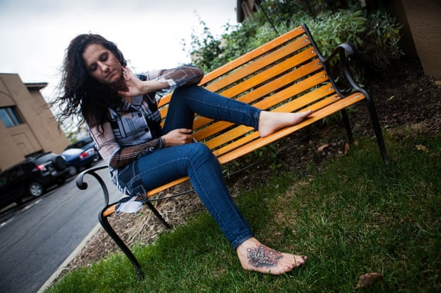 Christina, 29, a sex trafficking survivor, looks at her new foot tattoo. Christina had a trafficking branding tattoo covered up by artist Charles Waldo in a tattoo parlour in Lancaster, Ohio, USA. Christina was given a Survivors Ink scholarship to get her tattoo with the name of her husband and trafficker, covered with artwork.