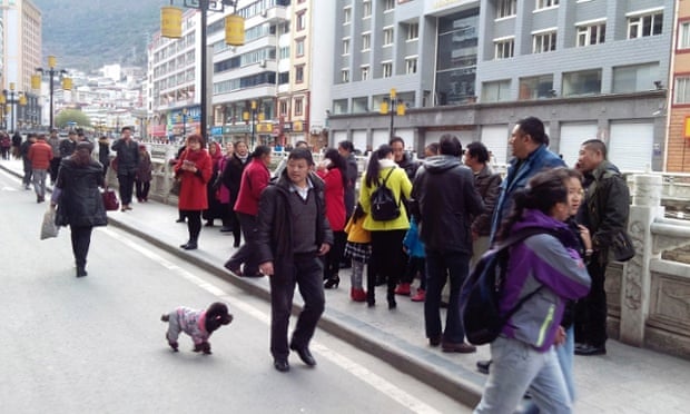 Residents stand on a street to stay away from buildings after the earthquake hit Kangding county, Sichuan province.