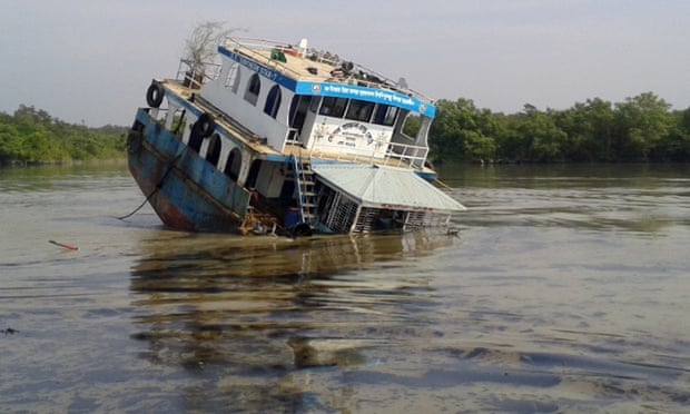 In this photograph taken on December 9, 2014, a Bangladeshi oil-tanker lies half-submerged after it was hit by a cargo vessel on the Shela River in the Sundarbans in Mongla. Bangladesh officials warned December 11 that an oil spill from a crashed tanker is threatening endangered dolphins and other wildlife in the massive Sundarbans mangrove region, branding the leak an ecological "catastrophe".