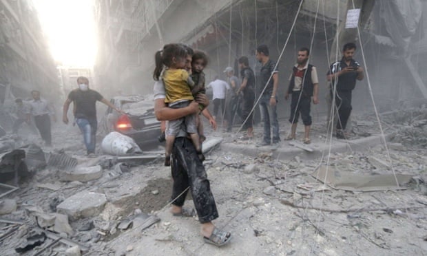 A man carries two girls to safety after a reported air strike by government forces on Aleppo.