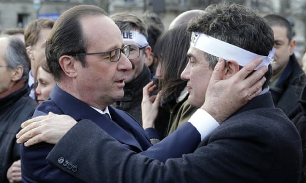Hollande comforts Charlie Hebdo columnist Patrick Pelloux at the solidarity march.