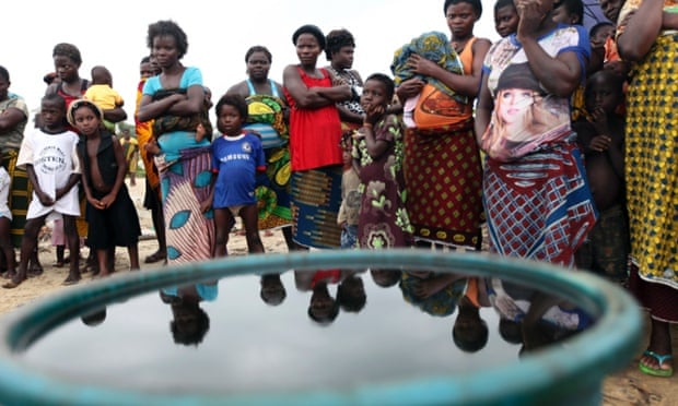 Villagers stand near a container containing crude oil collected by villagers as sample at the shore of the Atlantic ocean near Orobiri village, days after Royal Dutch Shell's Bonga off-shore oil spill, in Nigeria's delta state December 31, 2011.
