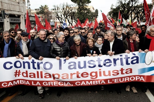 People hold a banner reading 'against austerity, Greece change, Europe change' at a rally in Rome