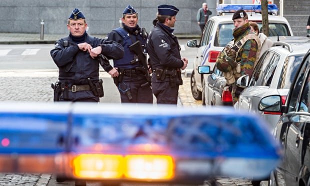 Policemen and a security officer stand outside a European parliament building in Brussels on Monday.