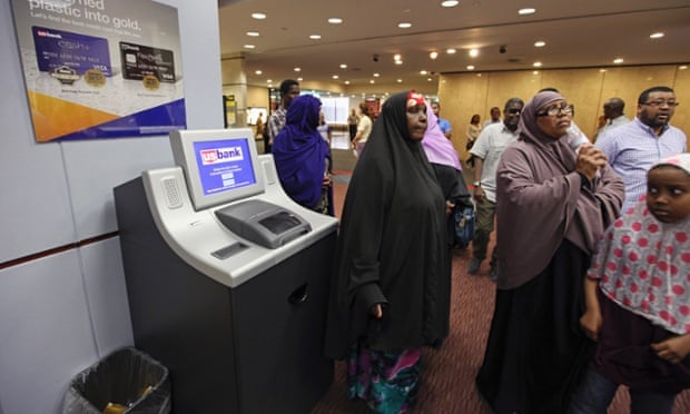 Members of the Somali community wait in the lobby as leaders try to get the attention of a U.S. Bank manager to give a letter requesting a meeting about the bank's announced closure of money transfers accounts to Somalia, in St. Paul, Minnesota June 27, 2014. Somali money transfer businesses are finding it increasingly difficult to find banks to work through to transfer money electronically to family in Somalia because of the U.S. government's increased regulations and scrutiny of accounts, enacted to prevent the flow of money to militant organizations.