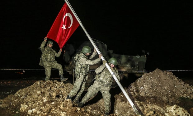 Soldiers raise a Turkish flag in the Esme region of Syria where the remains of Suleyman Shah have been relocated.