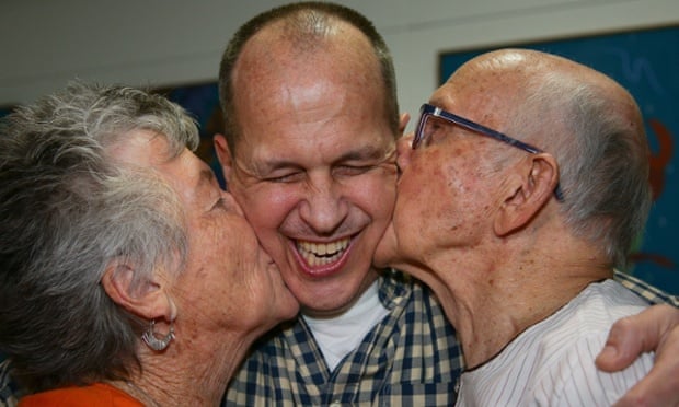 Al-Jazeera journalist Peter Greste is kissed by his mother Lois (L) and father Juris (R) upon his arrival at Brisbane's international airport