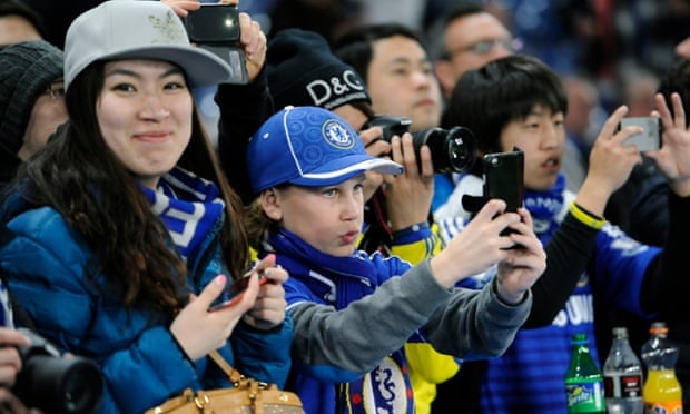 People at a football match using their phones
