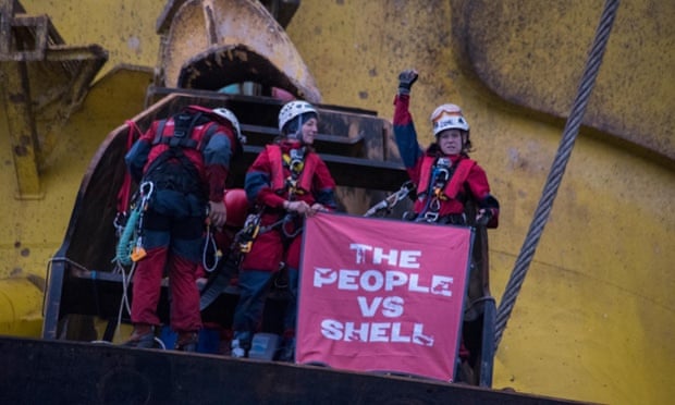 Greenpeace activists hold a banner that reads 'The People vs. Shell' as they scaled the Polar Pioneer drill rig in the Pacific Ocean. Six Greenpeace climbers have intercepted an Arctic-bound Shell oil rig in the middle of the Pacific Ocean, 750 miles north-west of Hawaii and have scaled the 38,000 tonne platform. At dawn this morning, the six, from the USA, Germany, New Zealand, Australia, Sweden and Austria, sped towards the Polar Pioneer, which Shell intends to use to drill for oil in the Chukchi Sea, in inflatable boats launched from the Greenpeace ship Esperanza.