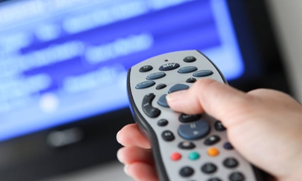 A woman uses a Sky remote control, whose pause button works better than the climate's.